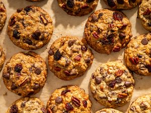 Rows of freshly baked ranger cookies with nuts chocolate chips and dried fruit as visible ingredients