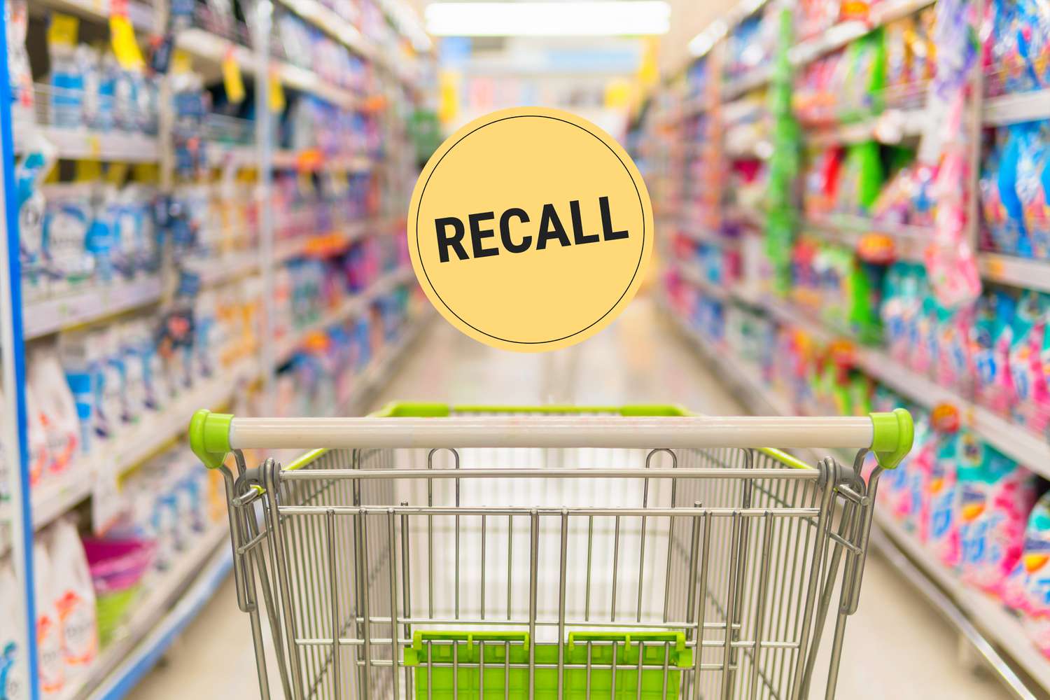 A shopping cart in a grocery aisle with a recall graphic over top