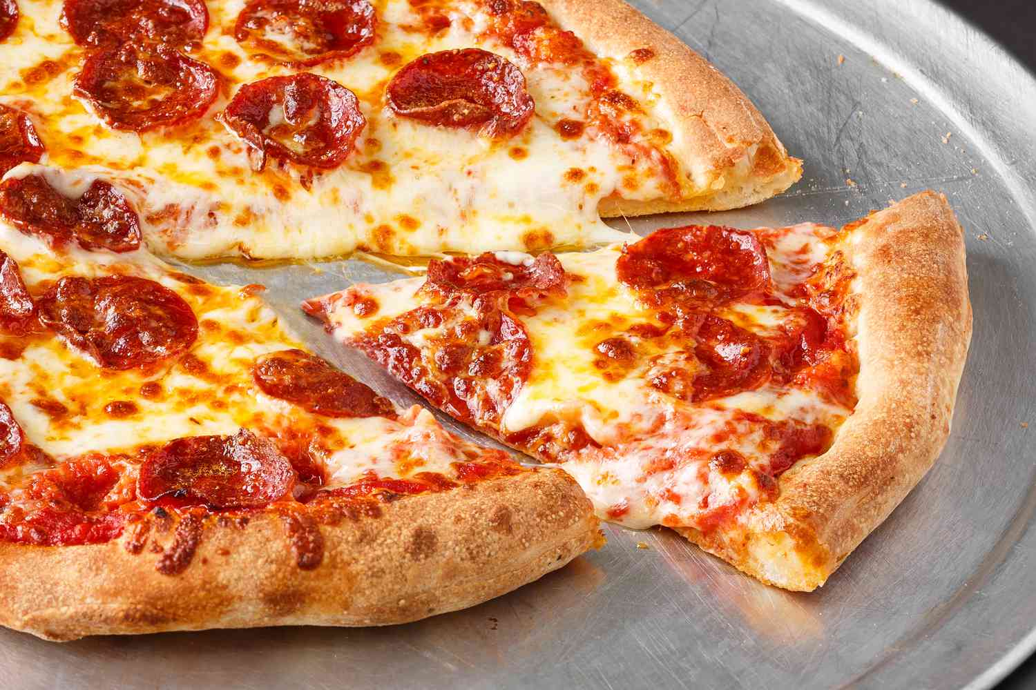 Sliced pepperoni and cheese pizza on a metal tray