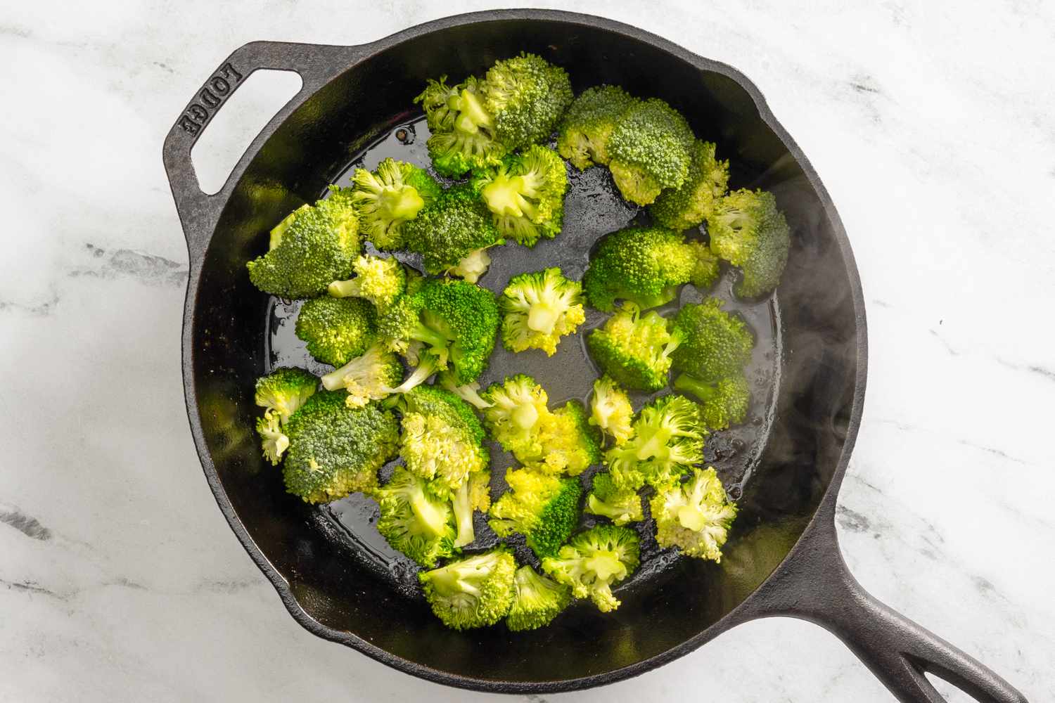 Broccoli cooking on a cast iron skillet for skillet chicken divan recipe