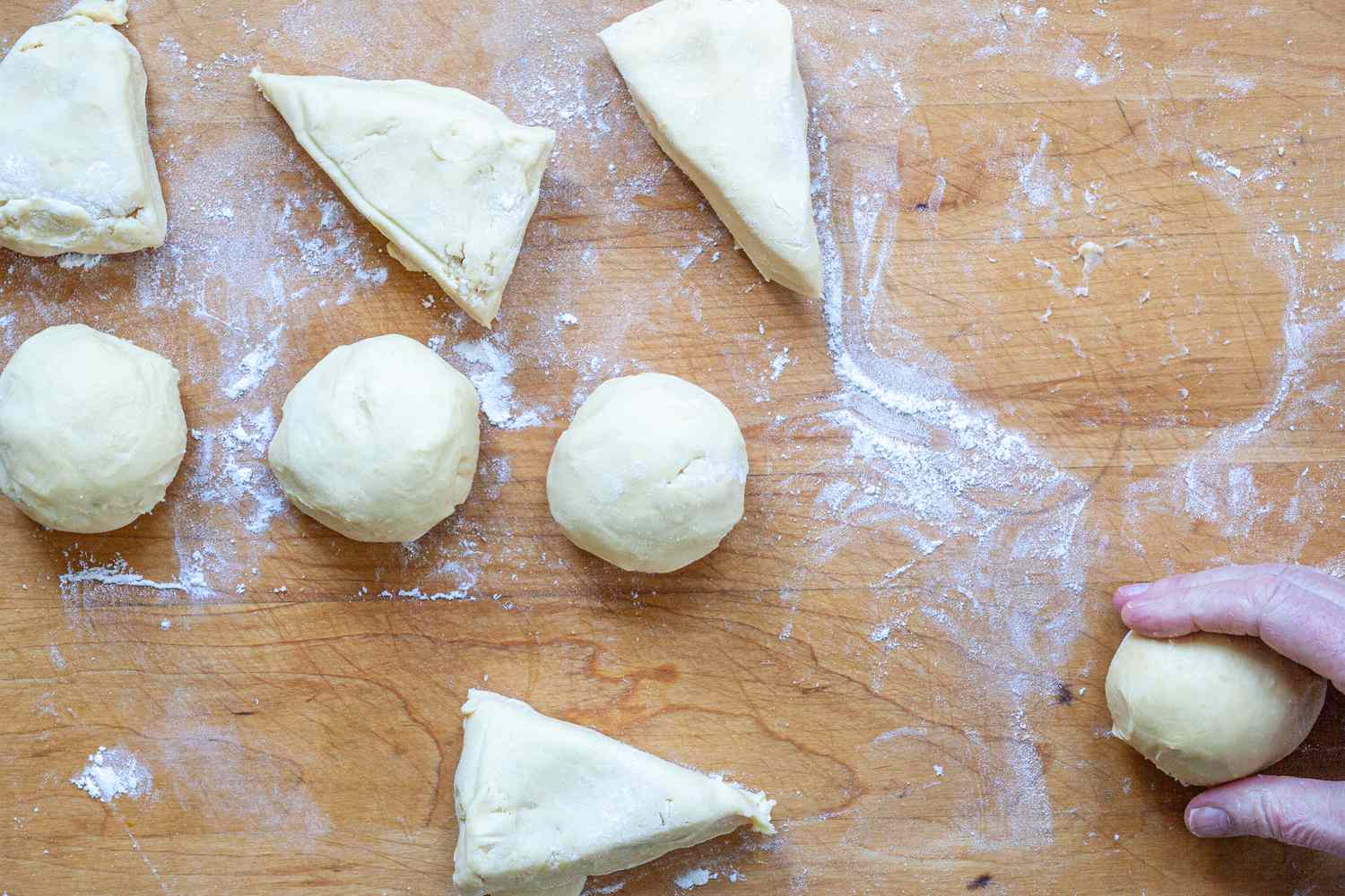 Rolling dough into a ball to make homemade brioche buns.