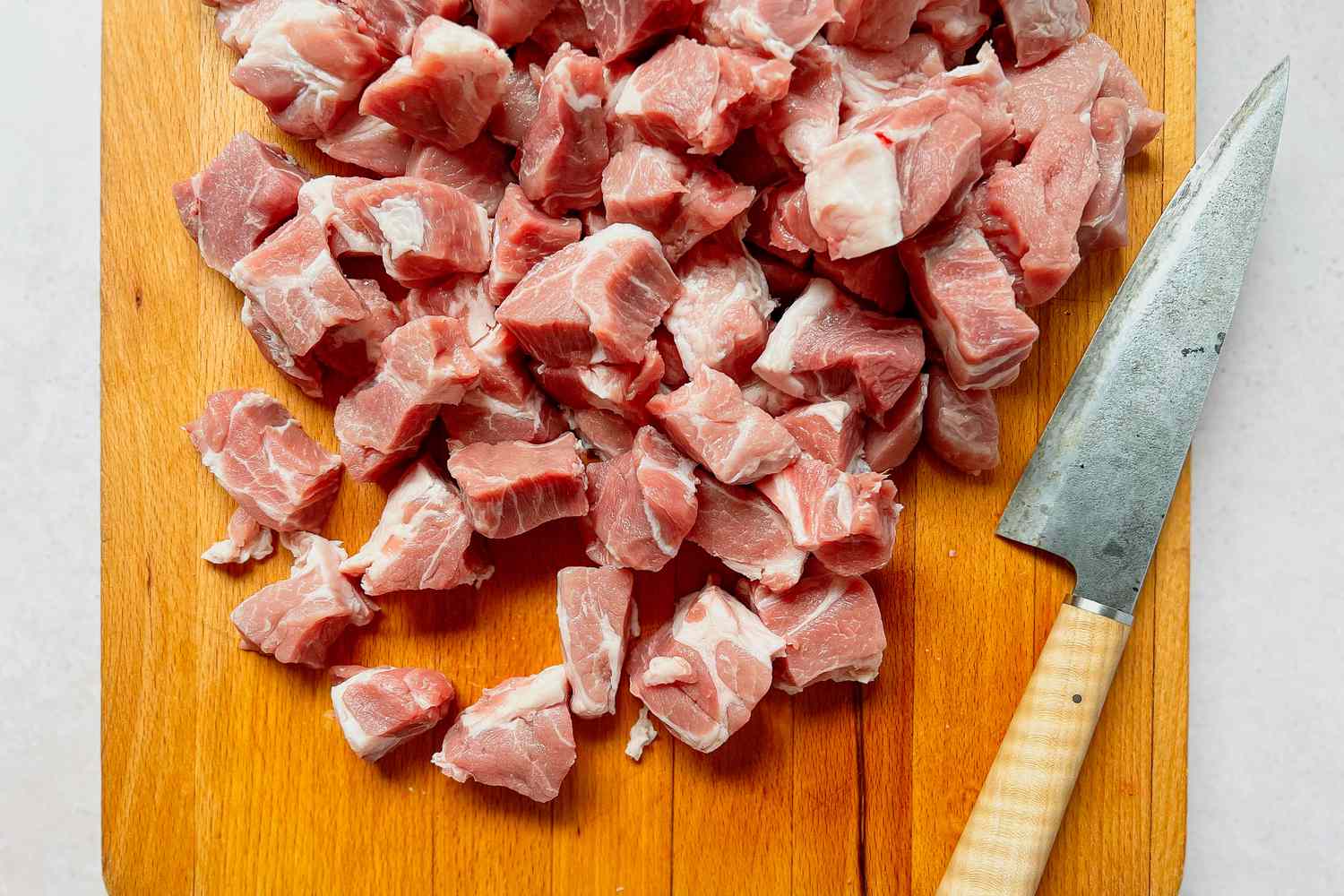 Pork Shoulder Cubes on a Cutting Board for Carnitas Recipe