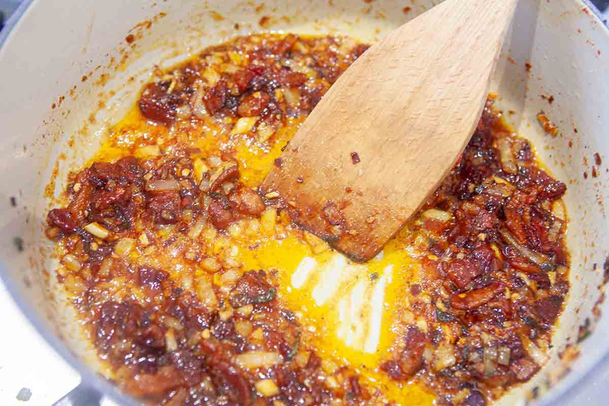 bacon, onions, and spices cooking for savory baked beans