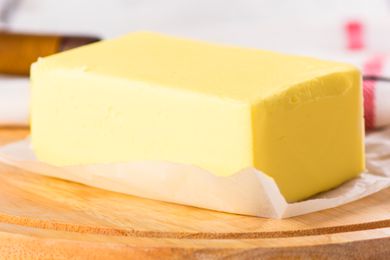 A close-up of a large block of butter on a piece of wax paper