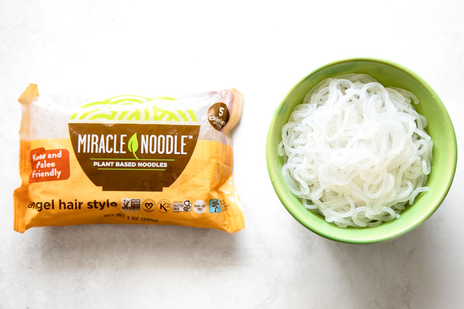 Dried Shirataki Noodles on the Left and Cooked Shirataki Noodles in a Bowl on the Right