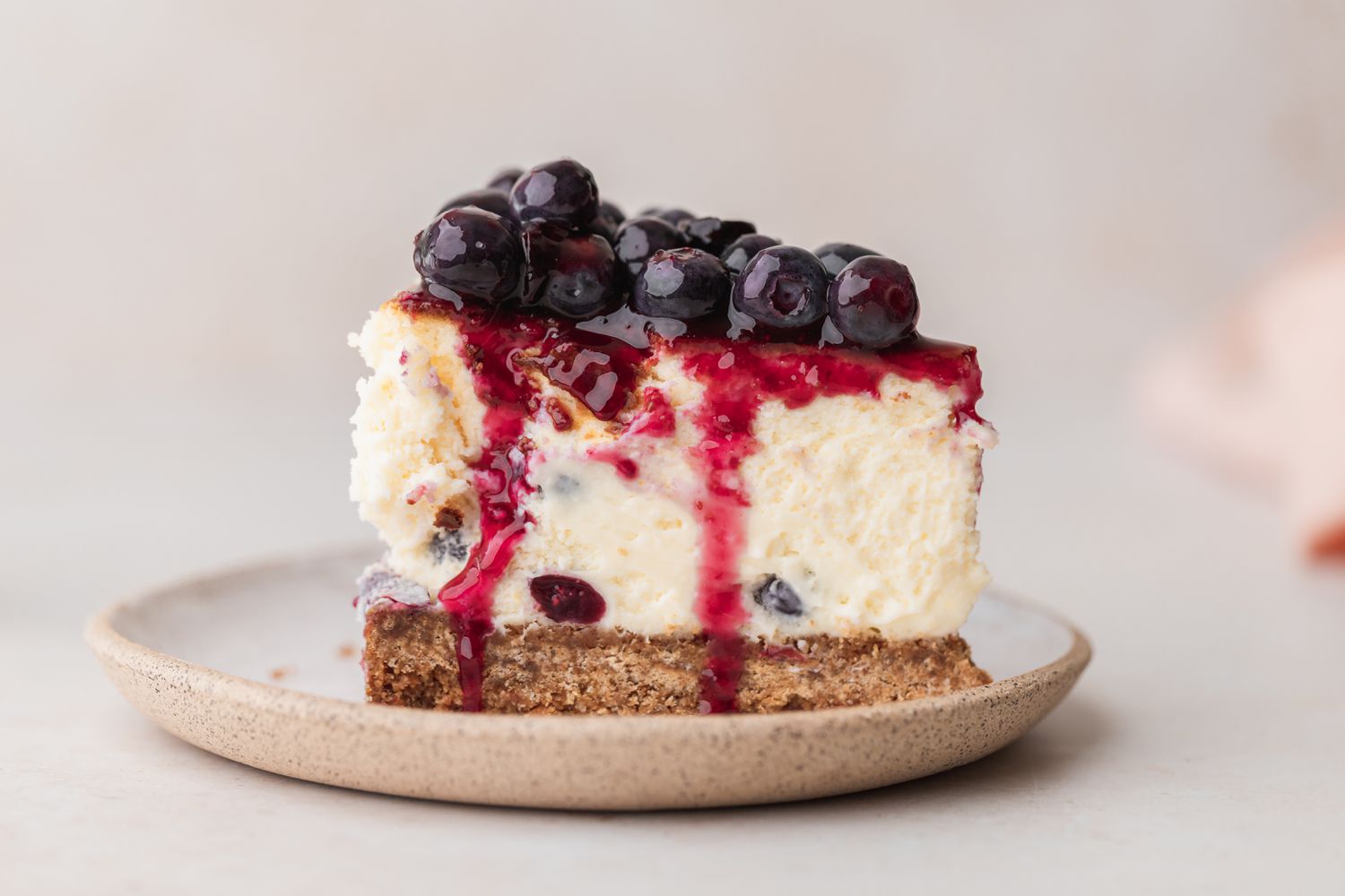 A slice of blueberry cheesecake on a plate.