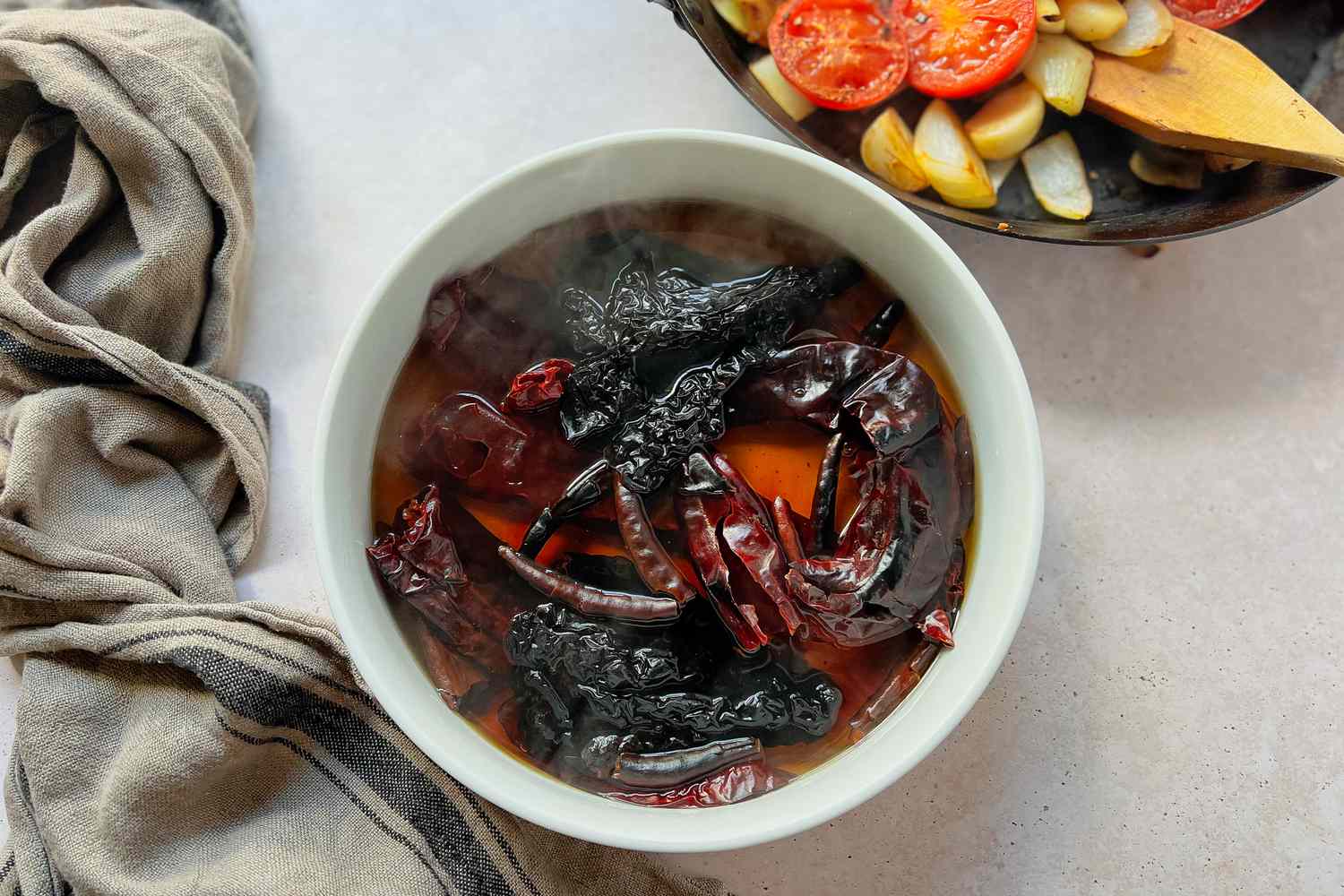 Toasted peppers being soaked in a bowl