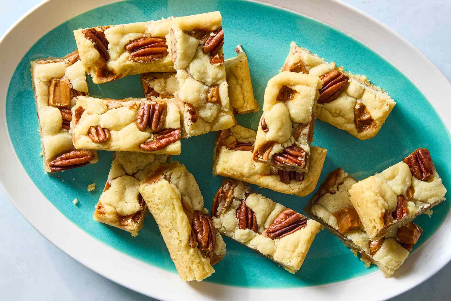 Overhead shot of pecan sugar cookies on a turquoise and white serving plate