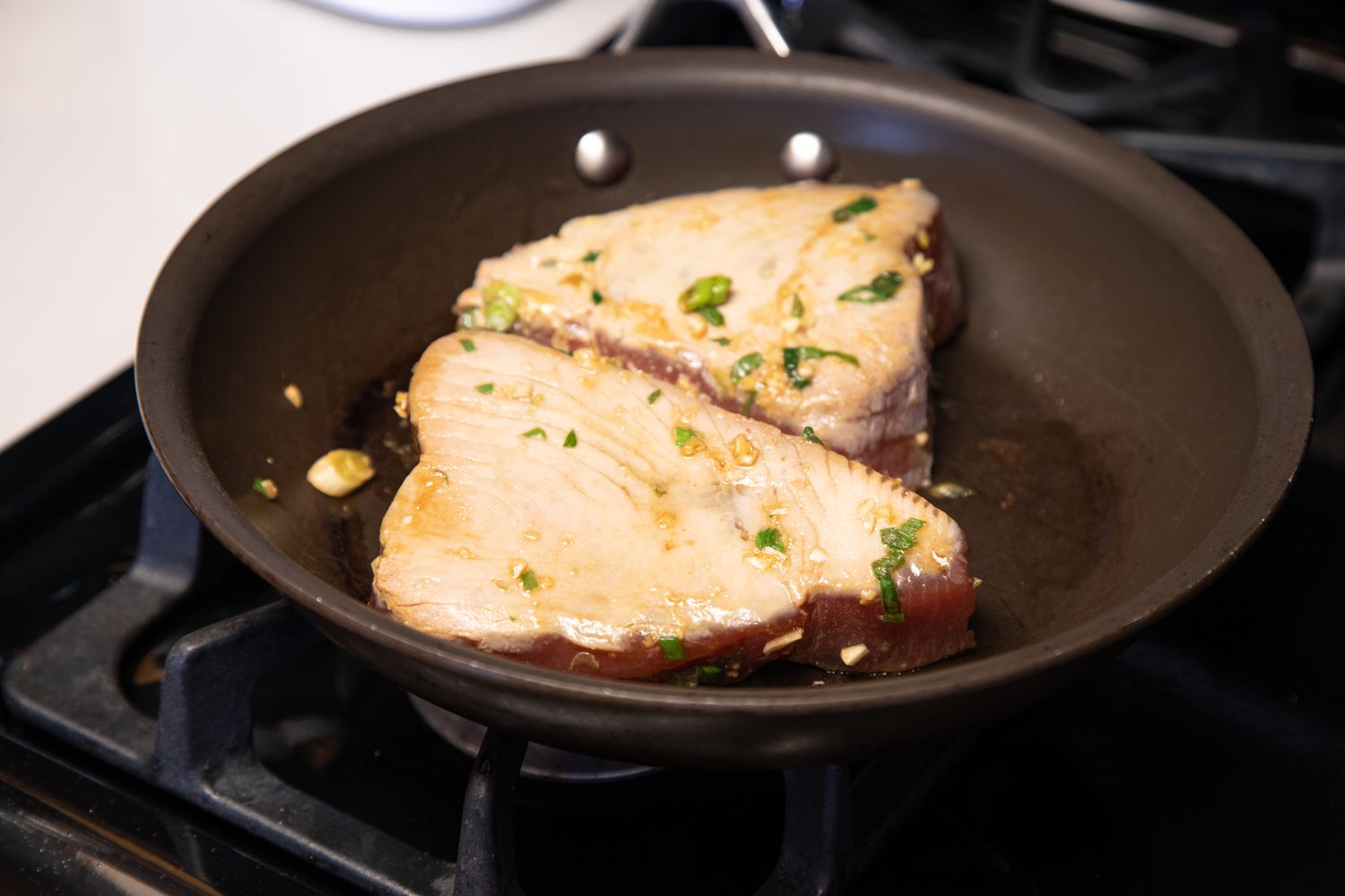 A skillet with seared ahi tuna cooking inside.