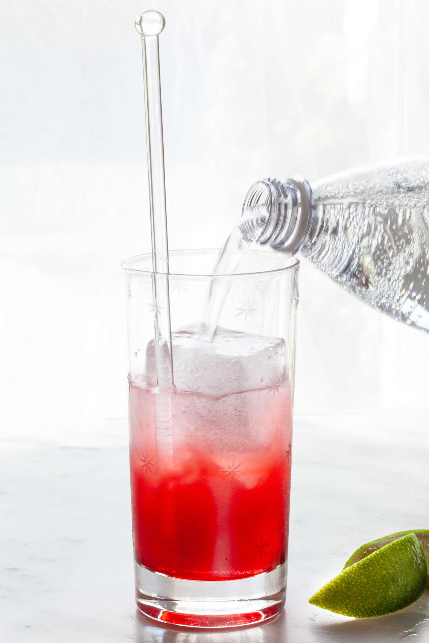 Making a raspberry lime rickey recipe in a highball glass.