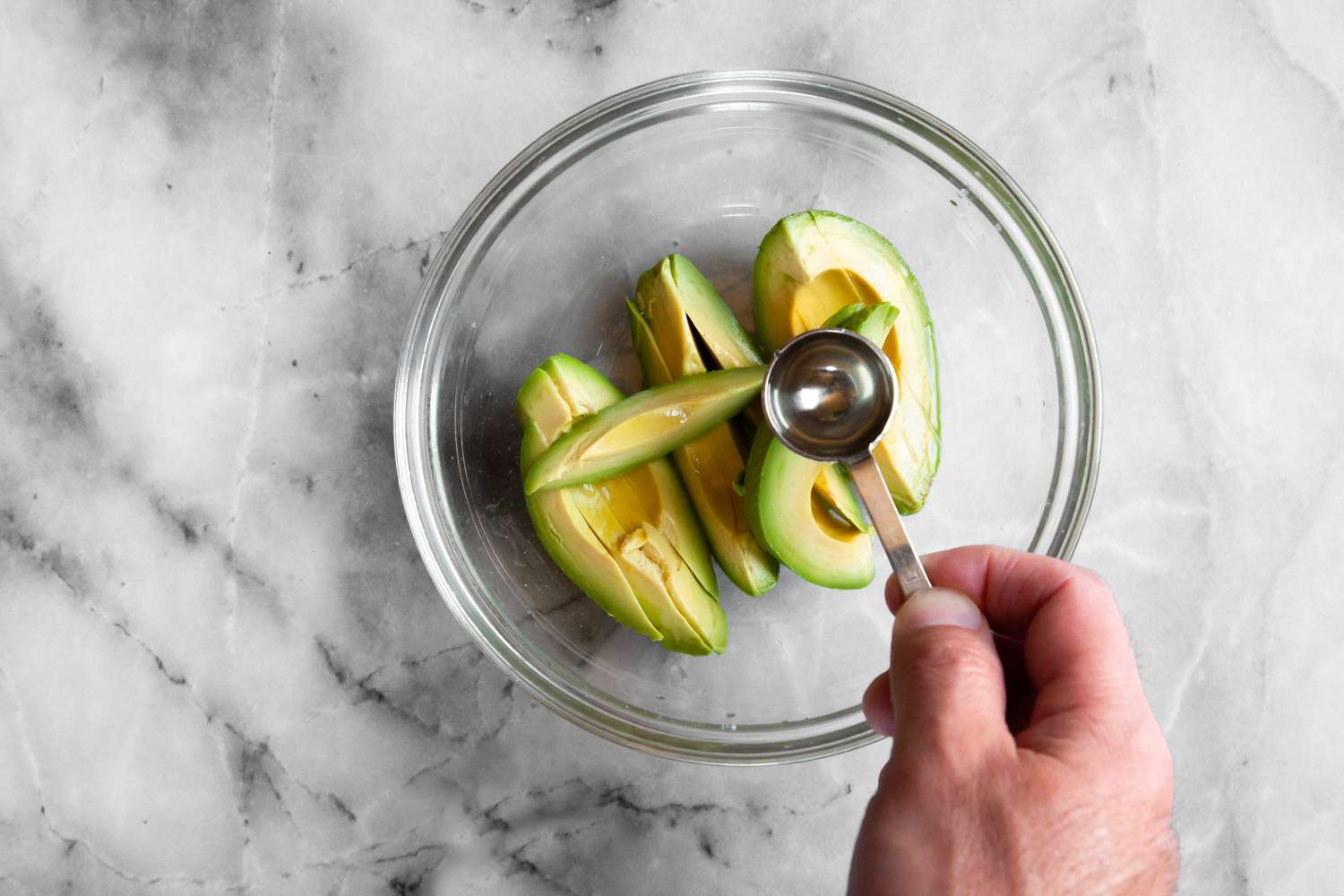 Rice Vinegar Added to Sliced Avocados for California Rolls