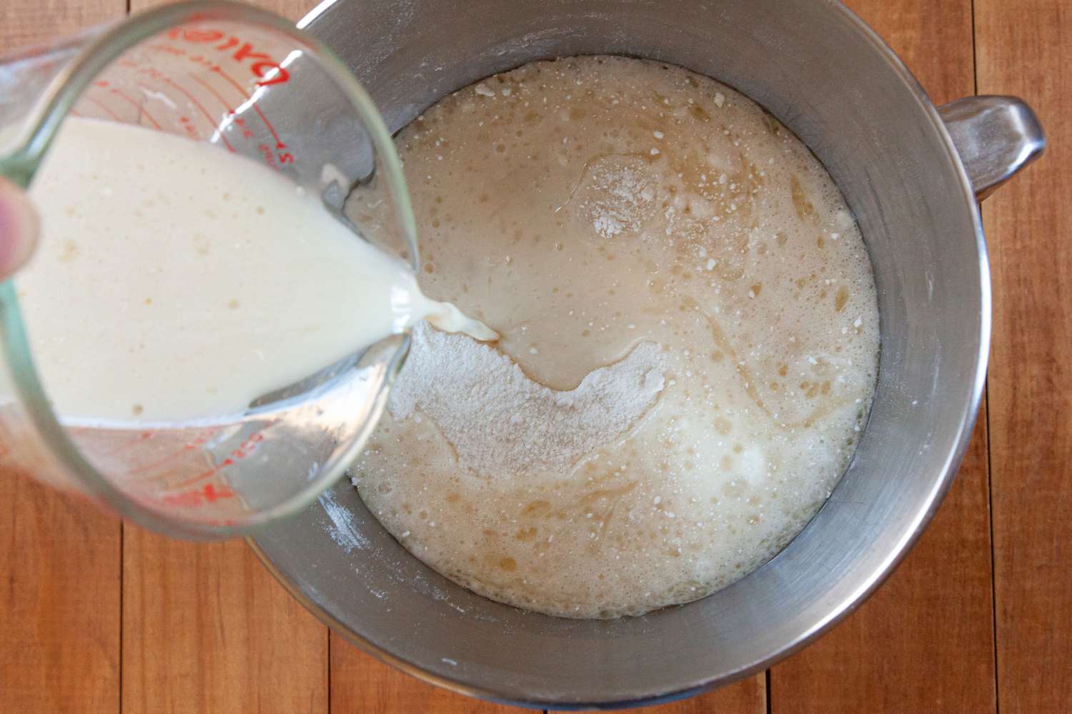 Adding liquid ingredients to the butter and sugar to make a fluffy white cake that tastes just like box mix.