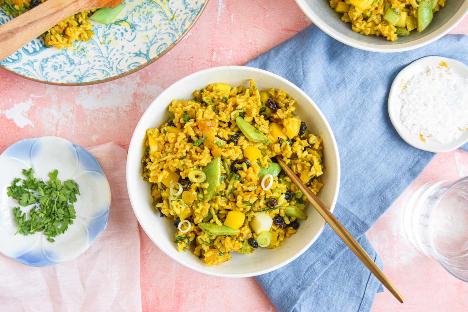 Curry Rice Salad Surrounded by Bowls, Cilantro, and Salt