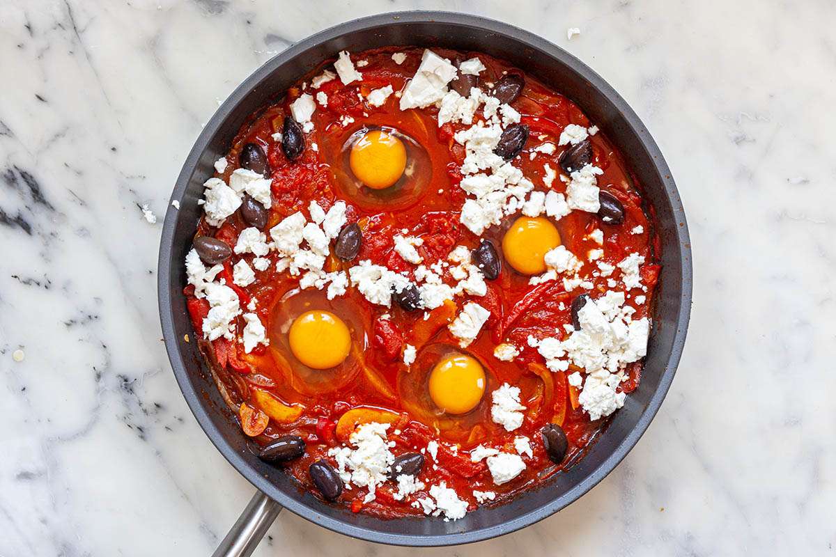 Feta added to the skillet to make Shakshouka.