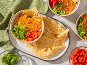 creamed tacos in bowl with chips, lettuce and tomatoes
