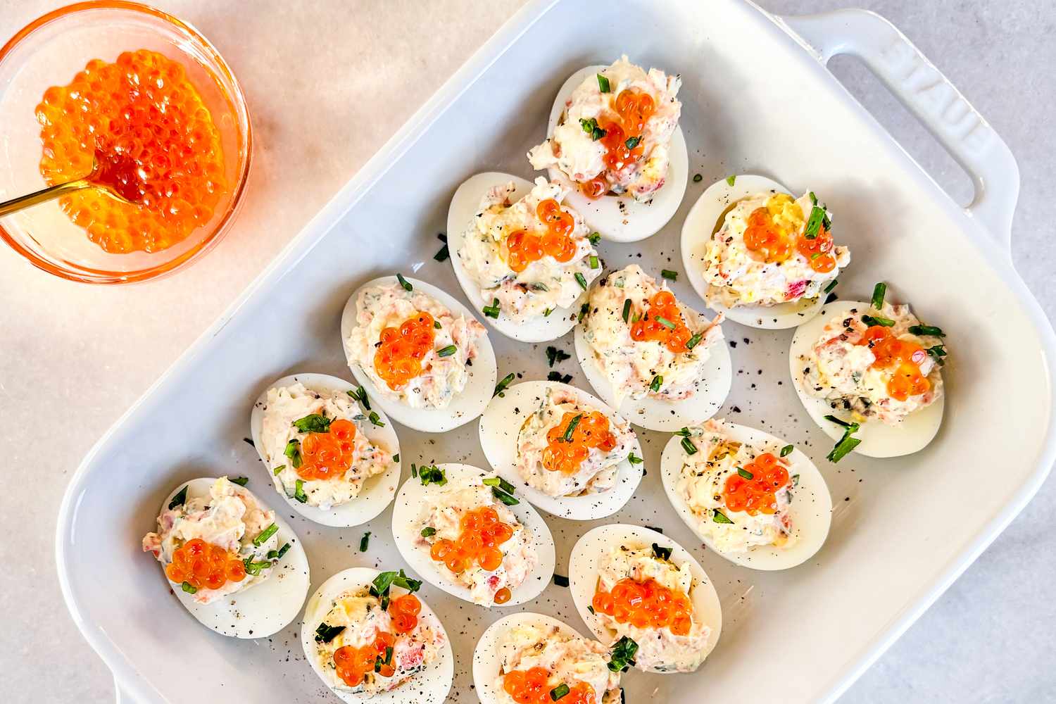 Closeup overhead shot of a tray of deviled eggs topped with salmon roe