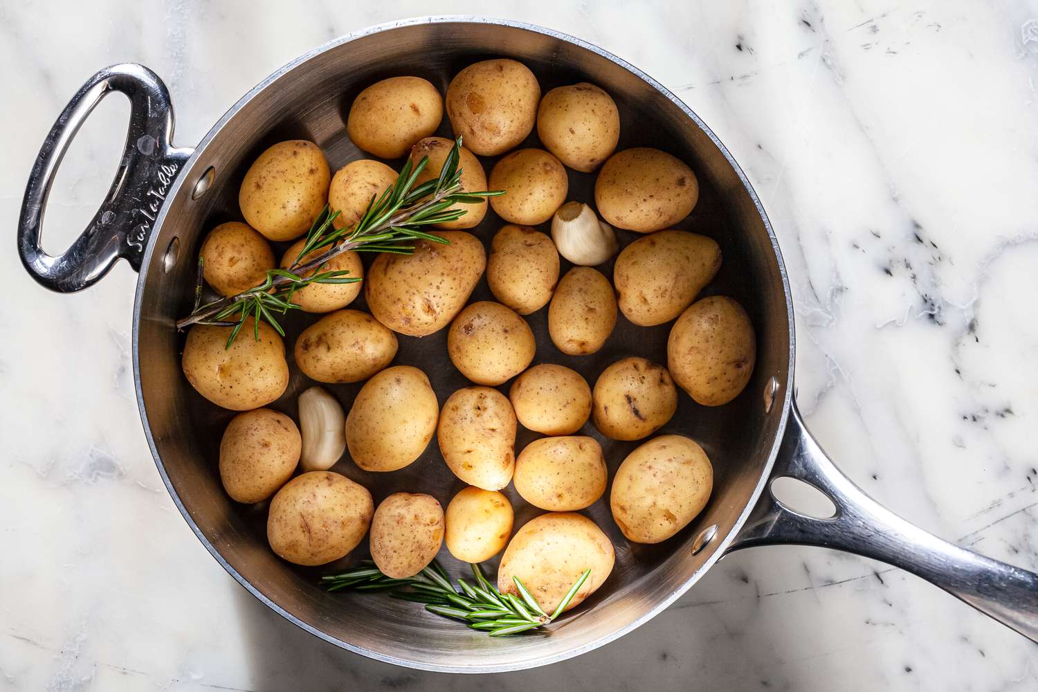 Add potatoes, rosemary and garlic in deep skillet. 