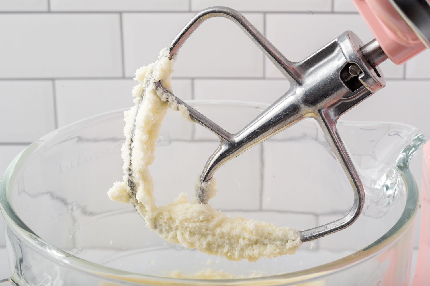 The paddle attachment with creamed butter and sugar on it to show how to make cupcakes.