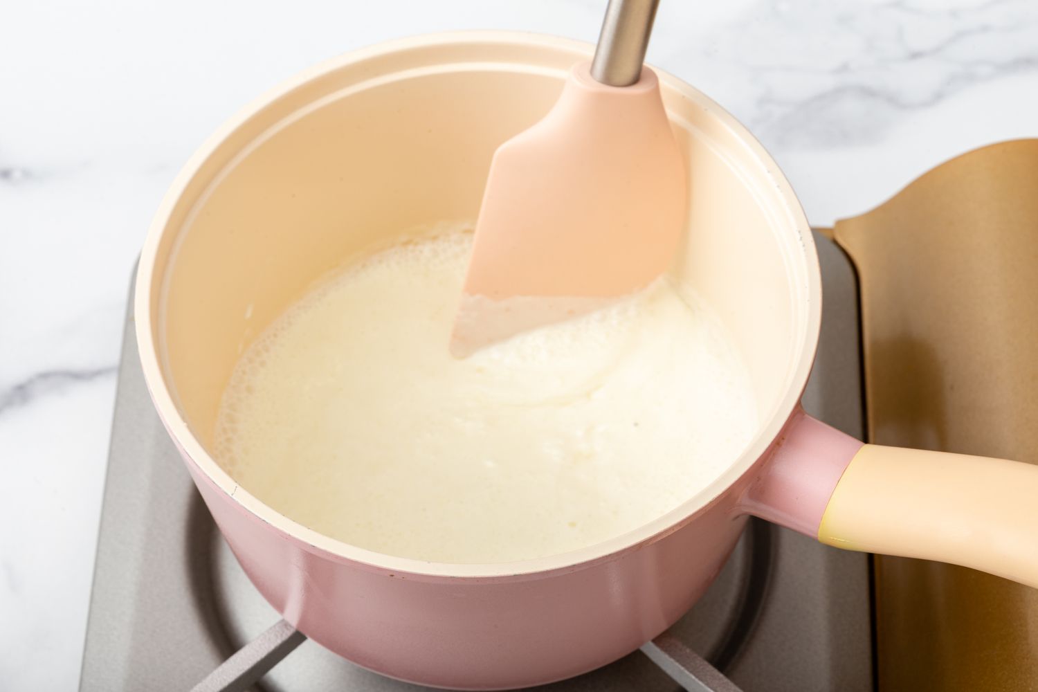Warming cream in a pan for a truffle recipe.