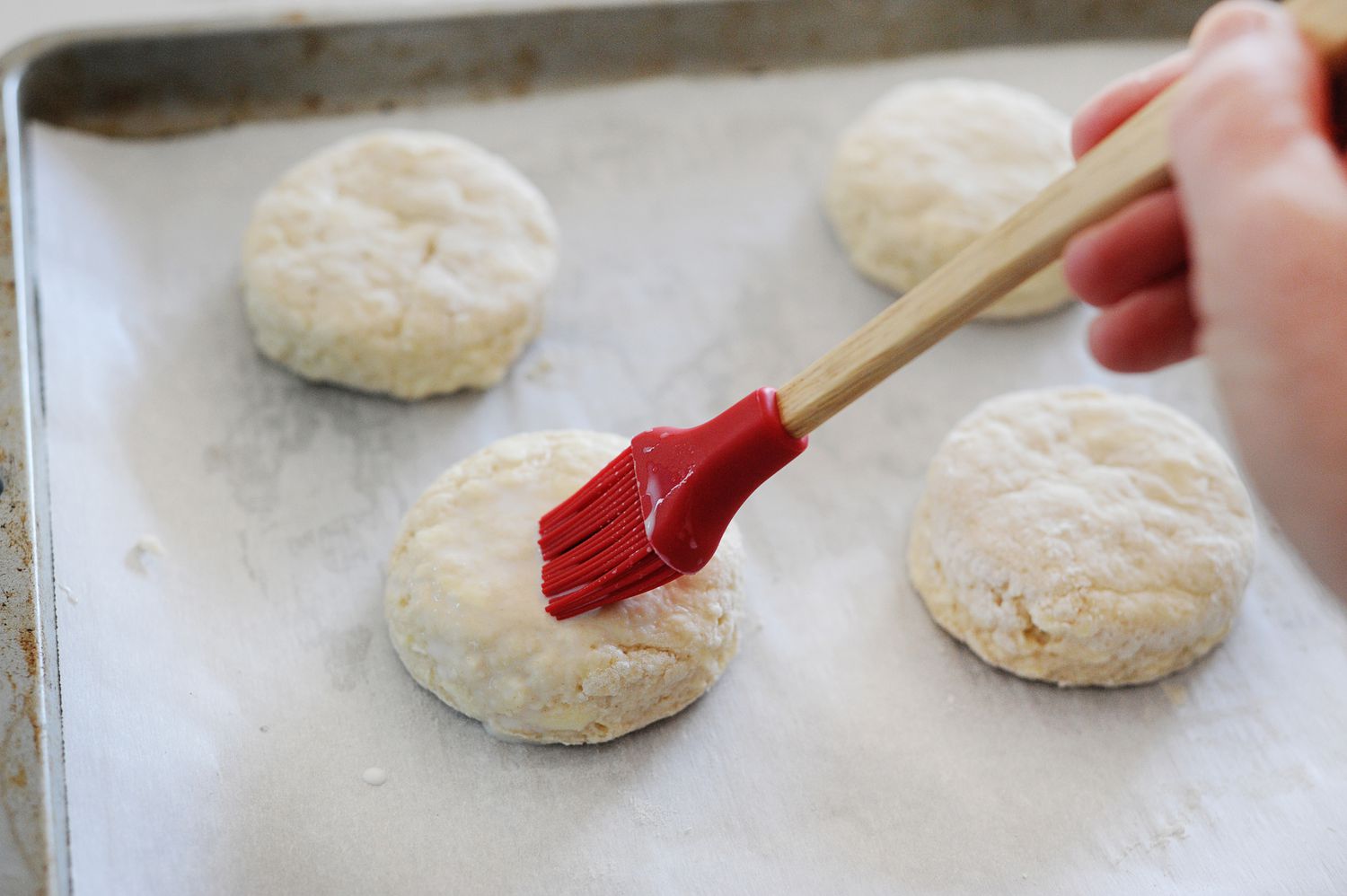 Brushing Authentic English Scones with milk before baking.
