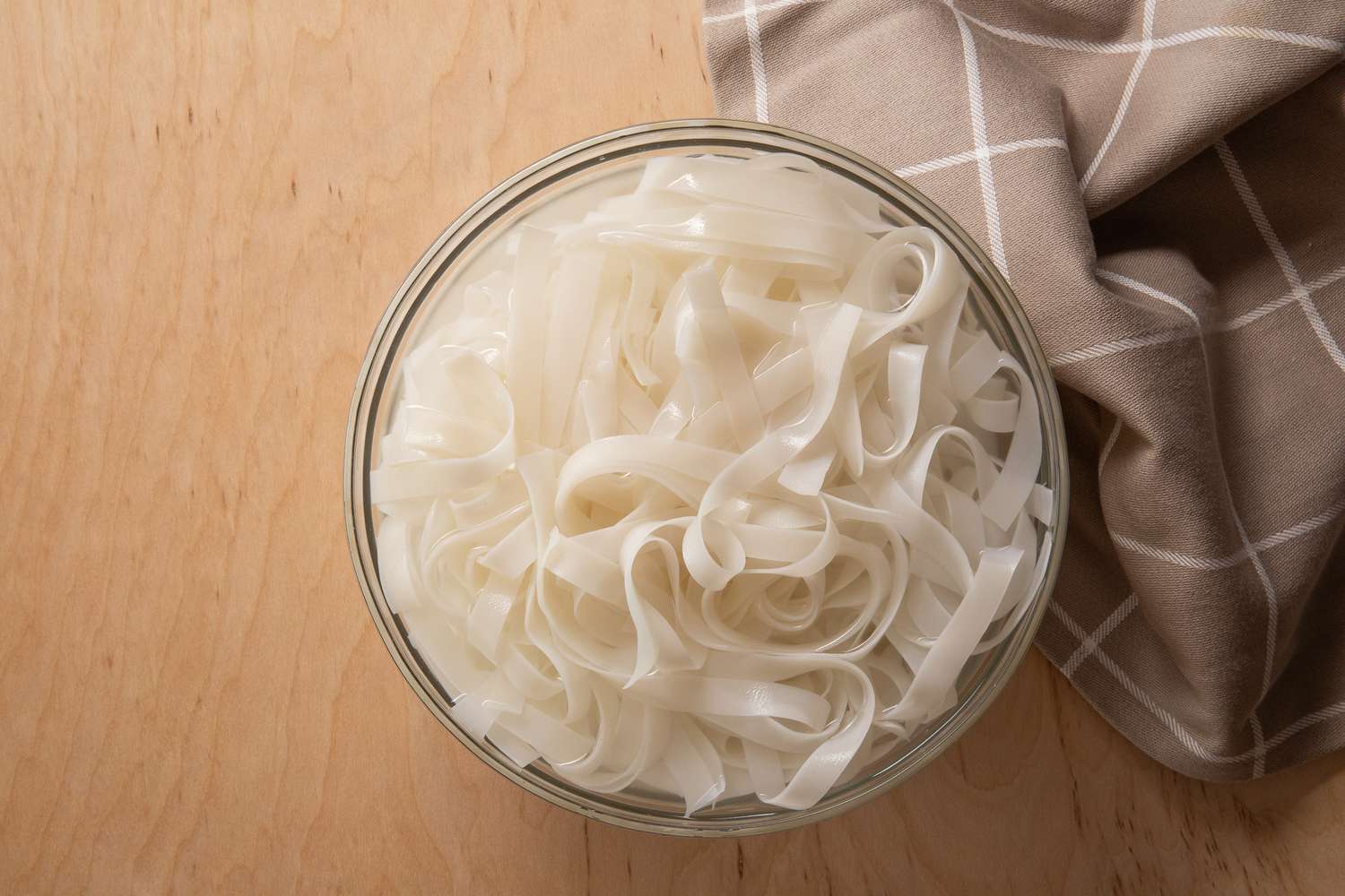 rice noodles in a bowl of water for pad see ew recipe