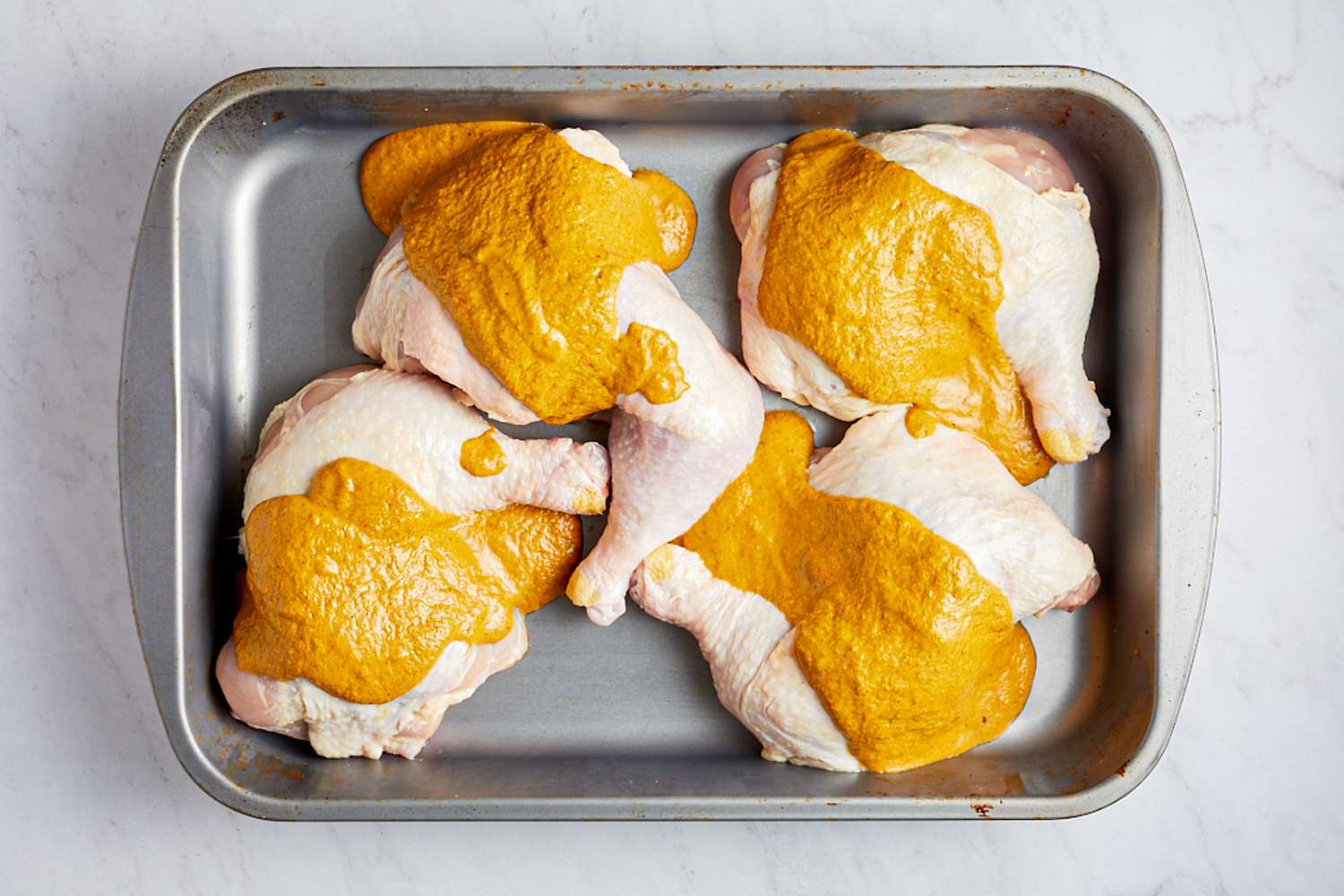 Chicken quarters with marinade on it for oven roasted piri piri chicken