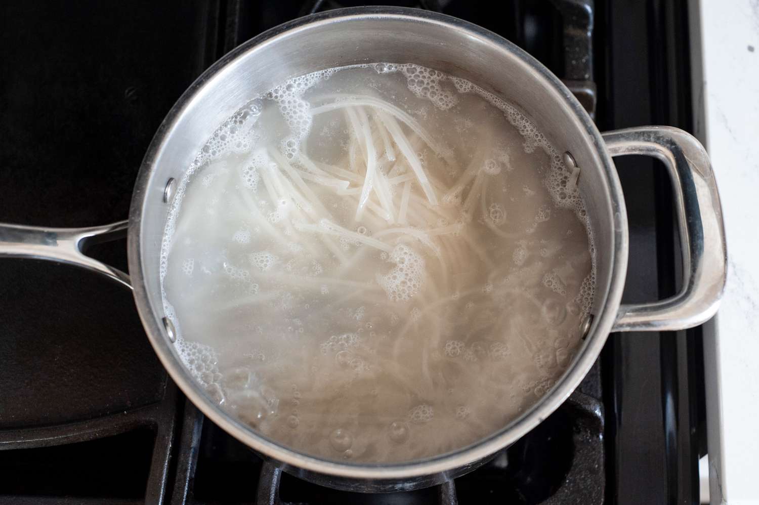 Soaking noodles to make a vegetarian rice noodle salad.