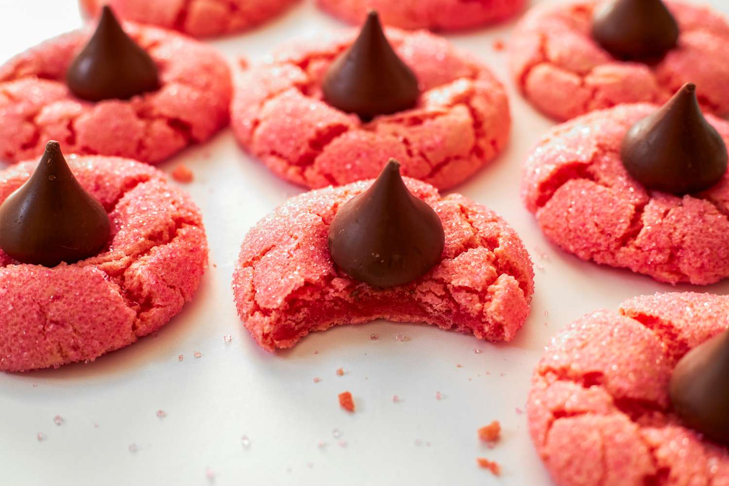 Angled view of strawberry chocolate kiss cookies on a white background