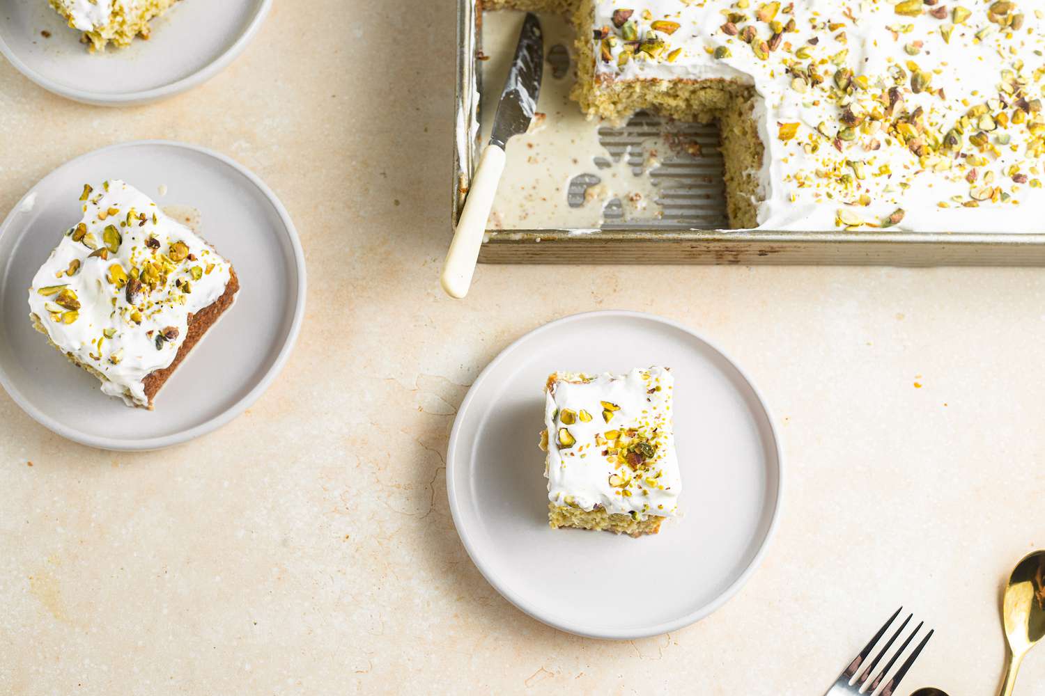 Plates of Tres Leches with Pistachio and Cardamom with the Rest in a Baking Tray