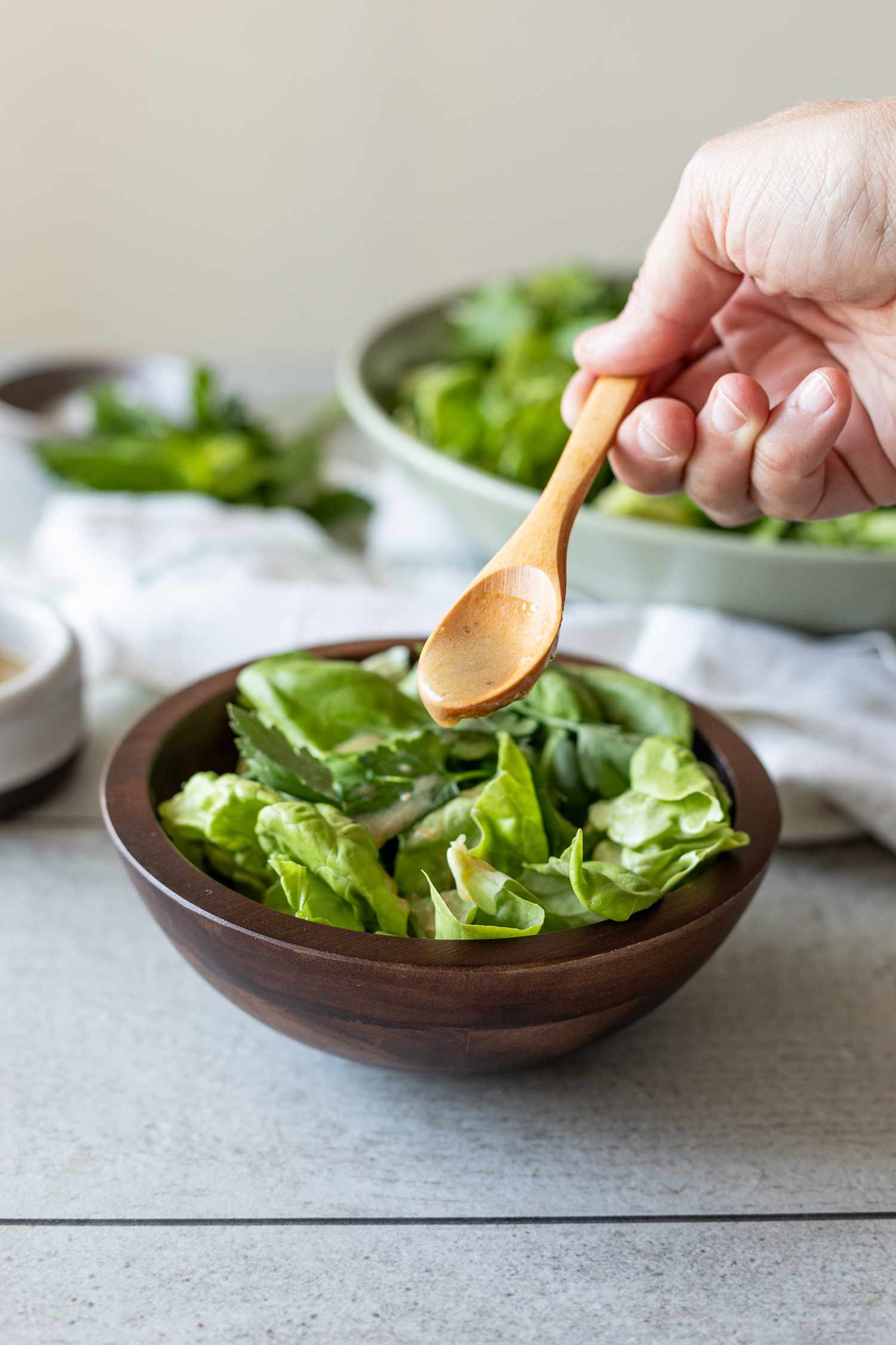 Red Wine Vinaigrette Spooned into a Serving of Green Salad with Fresh Herbs 