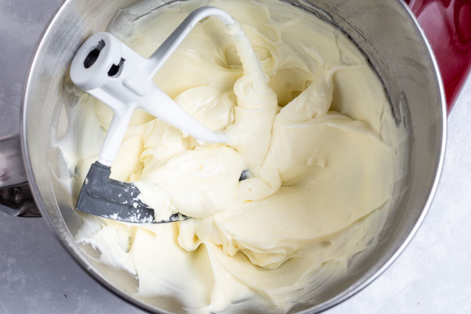 Mixing the ingredients in a stand mixer to make a no bake cheesecake recipe.