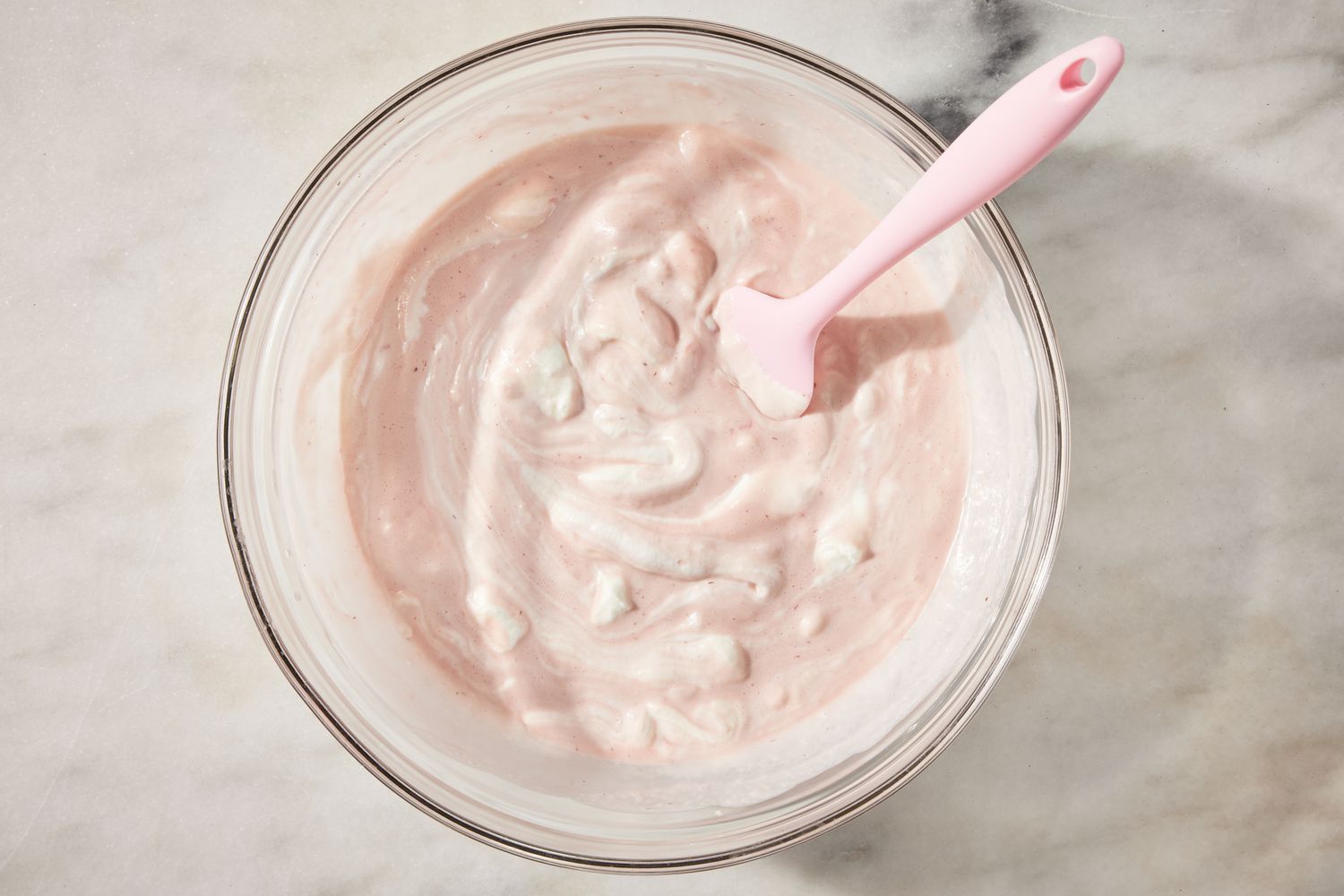 whipped cream folded into strawberry fluff mix in a bowl for strawberry marlow recipe