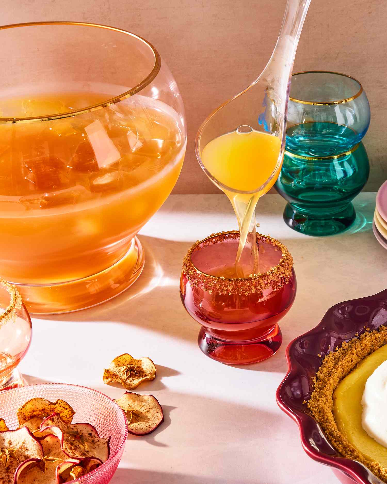 Serving bowl and glasses with cider punch and garnishes