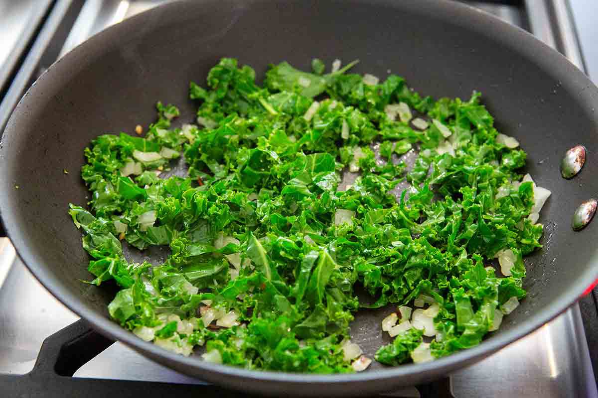 add chopped kale to onions in pan