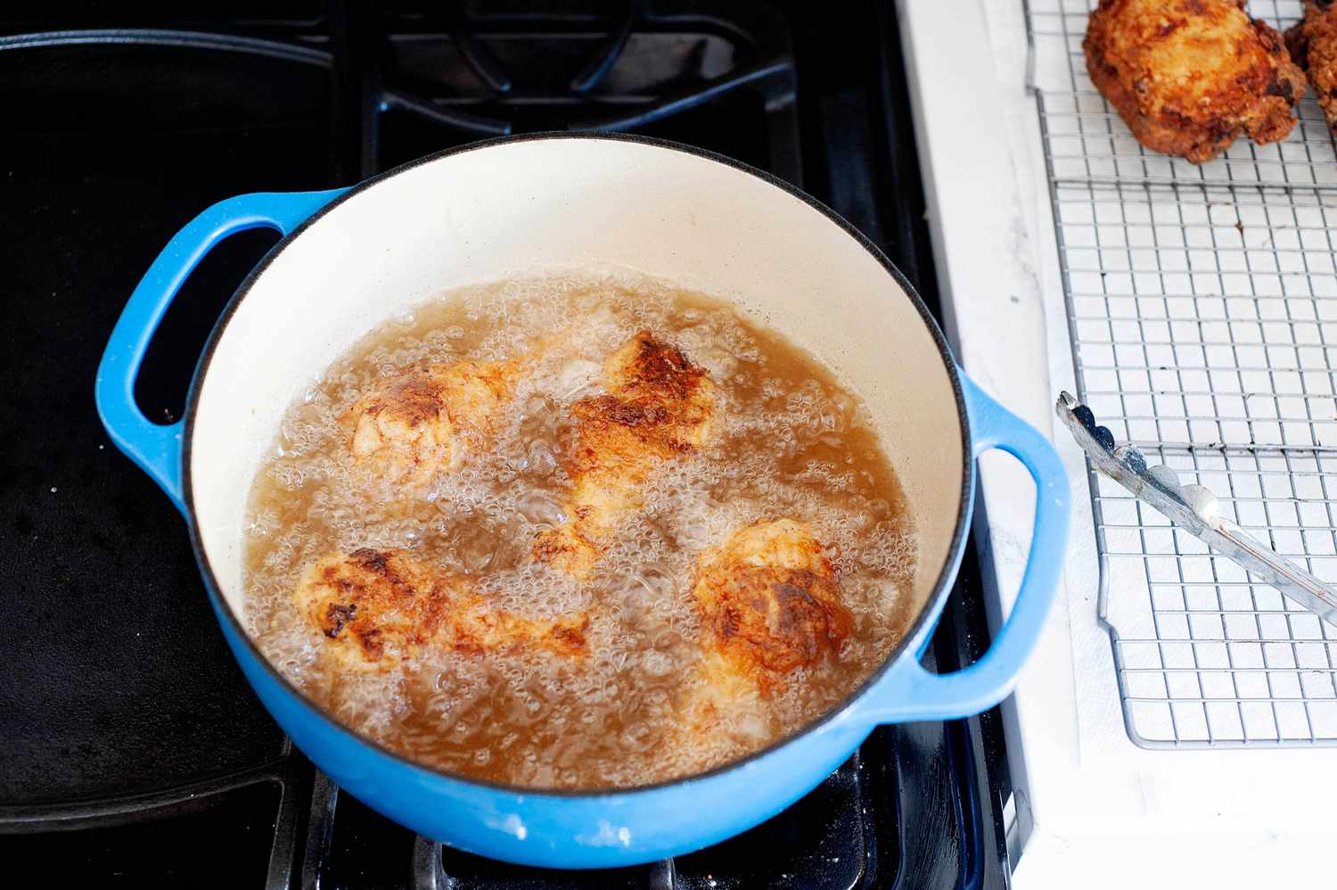 A dutch oven with oil and chicken to show how to fried chicken.