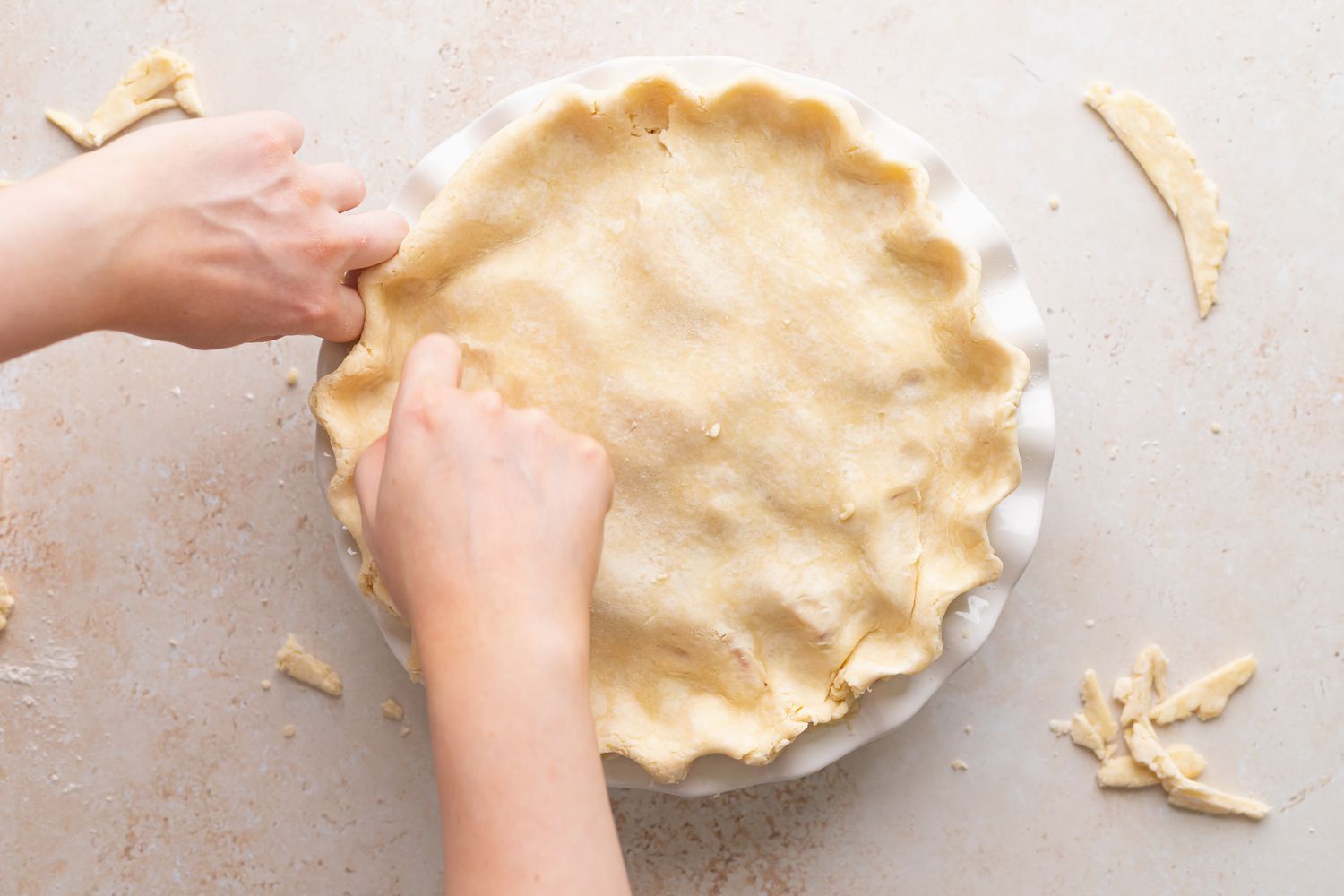 Crimping the edges of an easy peach raspberry pie.
