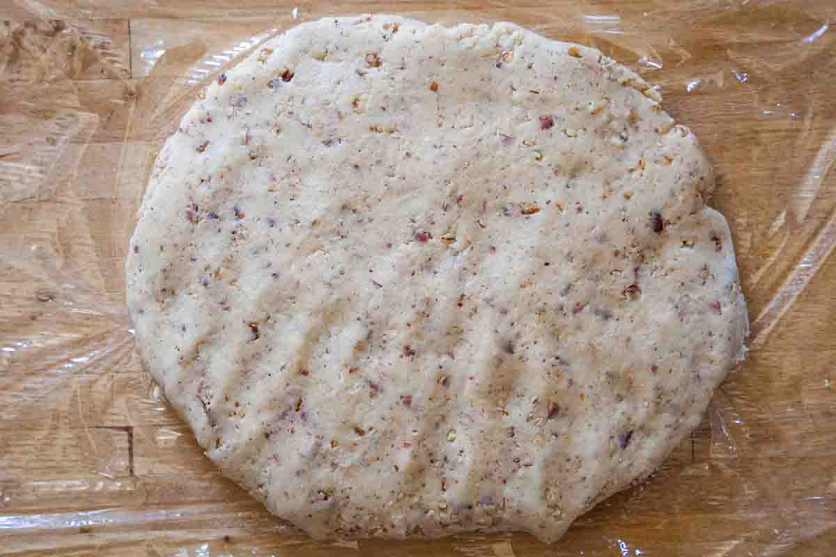Flattened Mexican Wedding Cookies dough on plastic wrap
