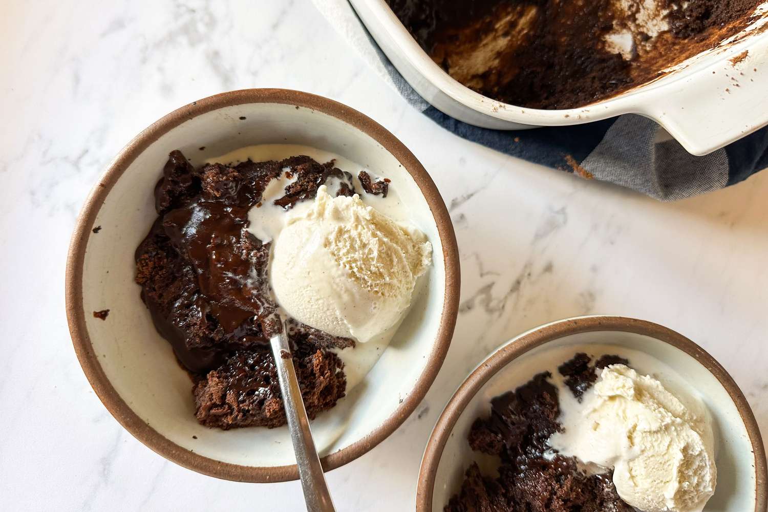 Samantha Seneviratne's 10-Minute Microwave Chocolate Pudding Cake in bowls with a scoop of ice cream and spoons