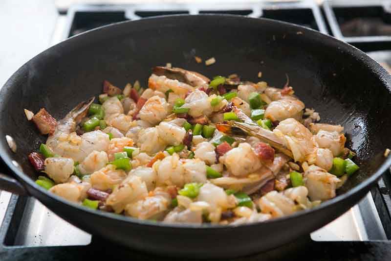 adding shrimp to sauteed vegetables