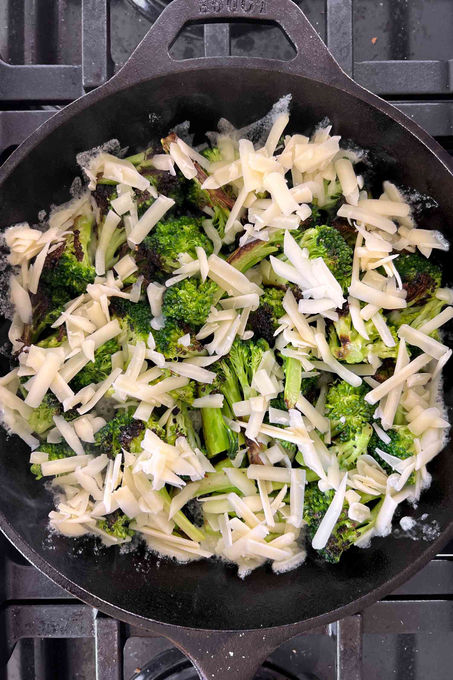 Cheese on broccoli in a cast iron skillet