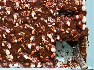 Overhead view of Mississippi Mud Cake in a blue baking dish with a serving utensil and one slice already removed