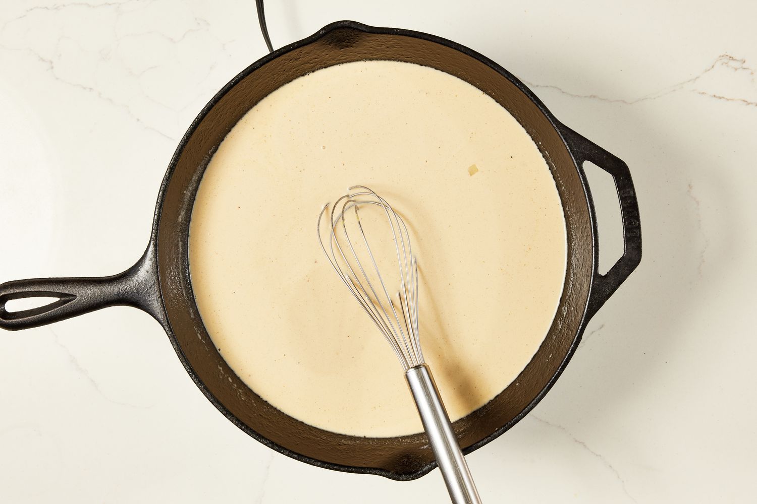 Sauce whisked together in the cast iron skillet for copycat Ikea Swedish meatballs recipe