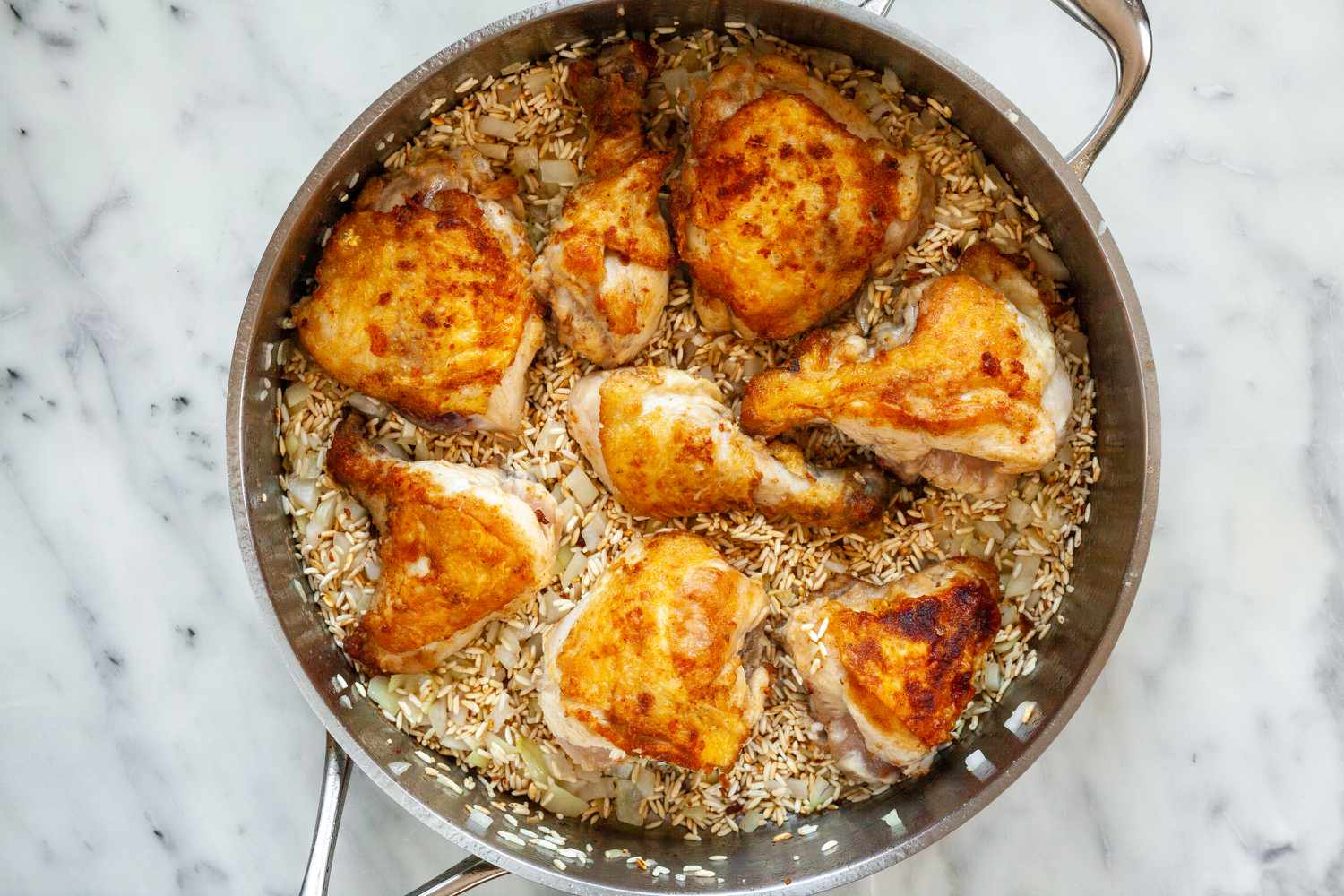 Overhead view of a deep skillet with pollo chicken inside.