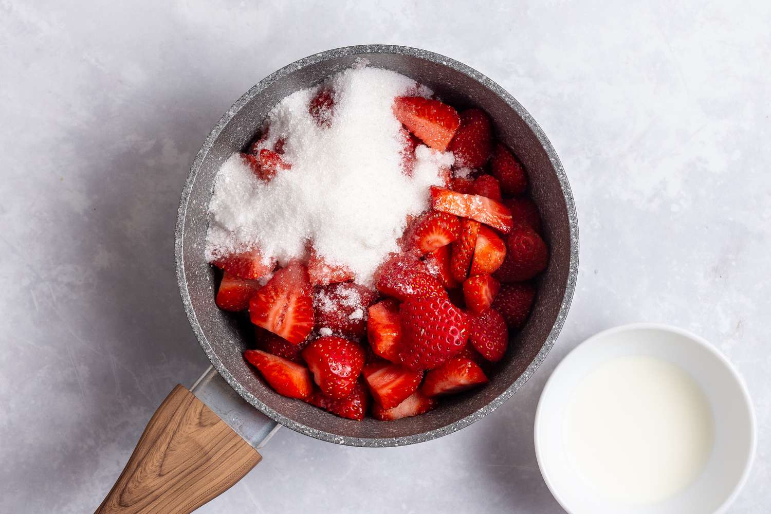 Strawberries and sugar in a pot for an easy no bake cheesecake recipe.