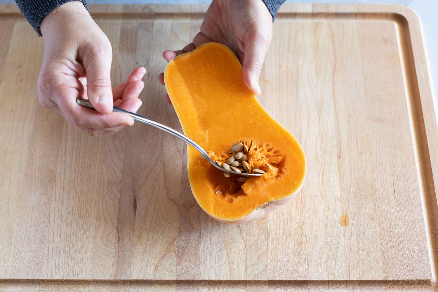 Scoop out the seeds of a butternut squash and discard