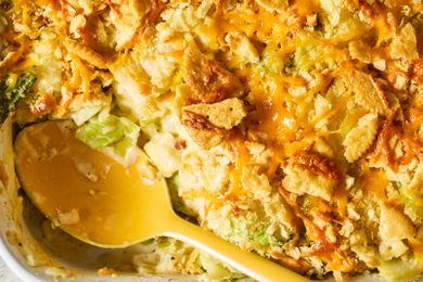 A serving of baked cabbage casserole with cheese and crispy toppings a yellow serving spoon in the dish
