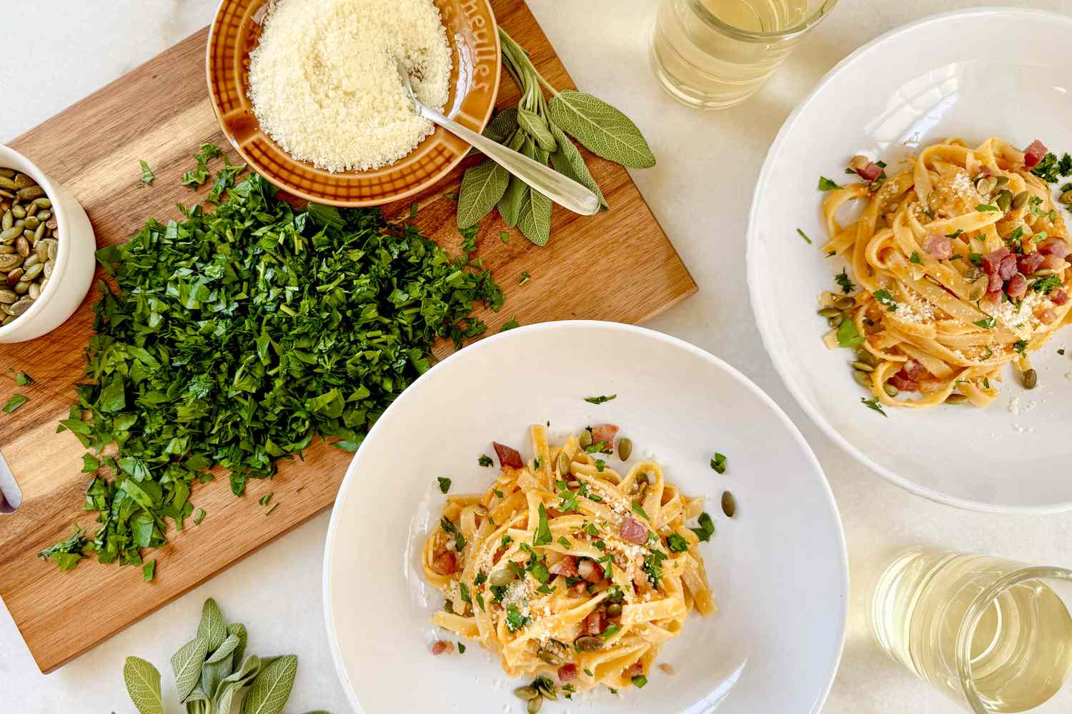 Plate of pasta with garnishes and herbs on a wooden board