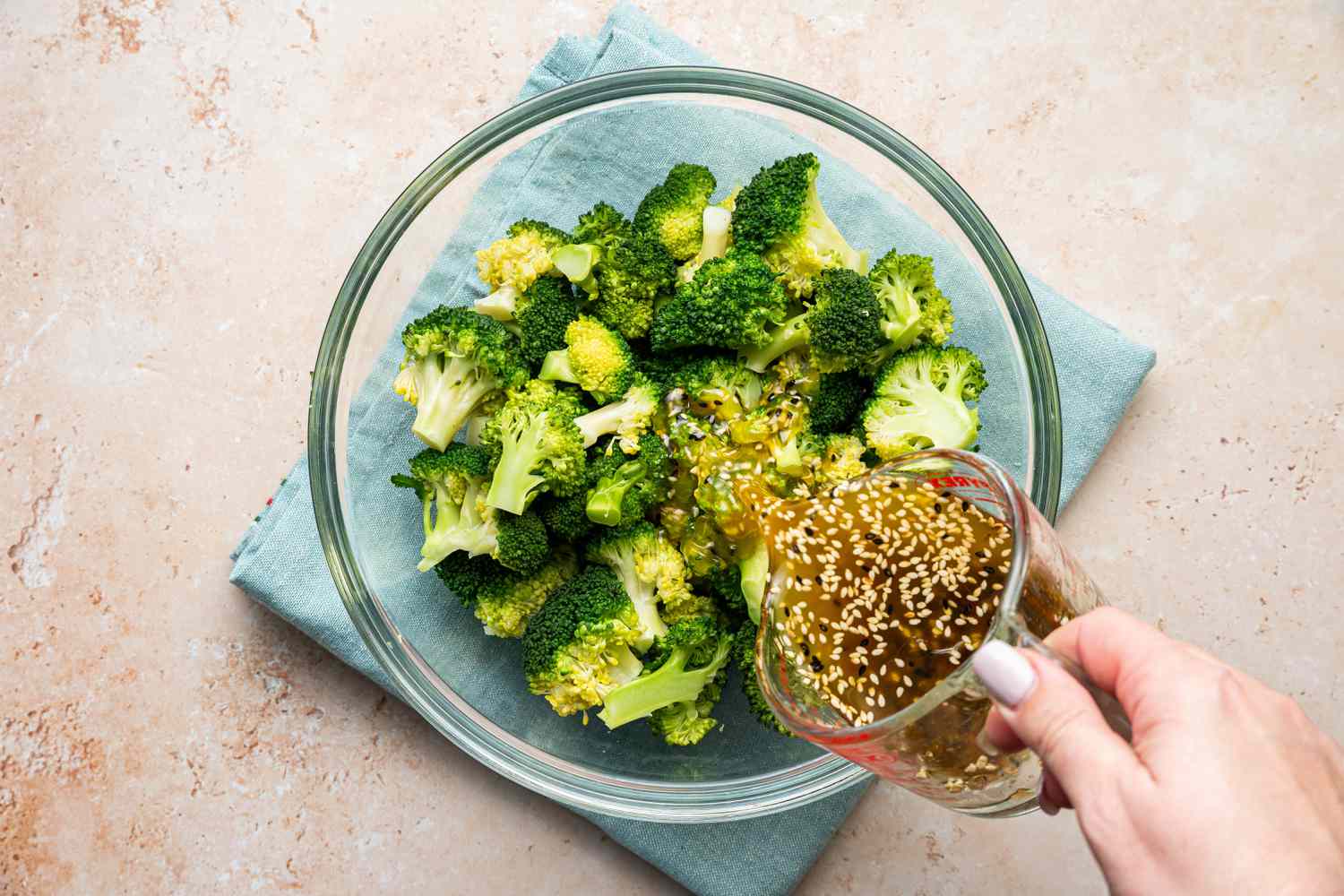 Sesame Dressing Poured into Bowl of Microwave Broccoli