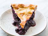 A slice of Blueberry Pie on a white plate