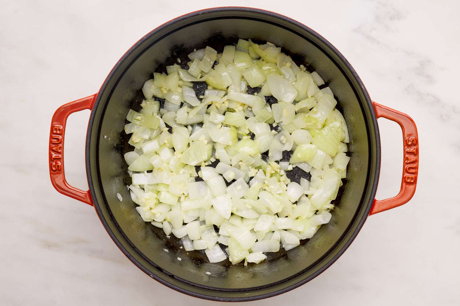 Aromatics sauteed in a Dutch oven for spinach artichoke dip soup recipe